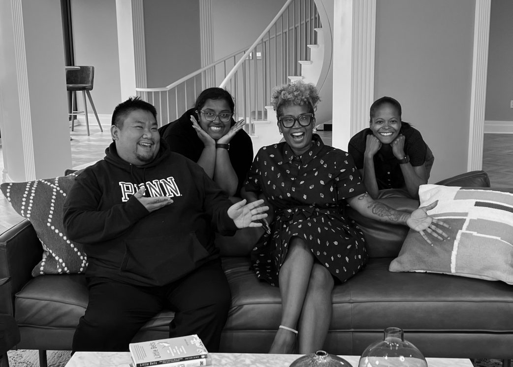 Four leaders of color sit together on a couch and strike silly poses.